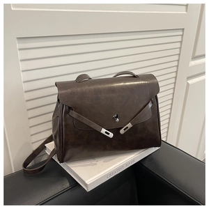 Detailed macro view of dark brown matte leather texture and elegant metal twist lock buckle