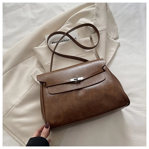 Detail of dark brown vintage leather shoulder bag with silver turn-lock and soft texture