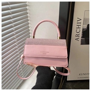 Detailed view of pink leather crossbody bag with sparkling rhinestones and sturdy handle