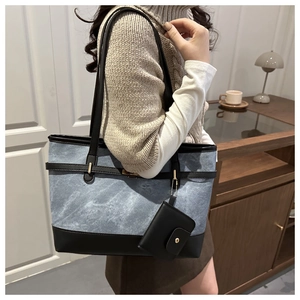 Detail of blue denim tote bag with leather straps and detachable coin purse accessory
