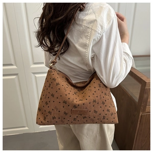 Detail of vintage brown corduroy tote bag featuring bow patterns and a leather fashion patch