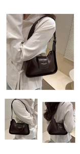 Detail showing deep brown glossy leather shoulder bag with fashion text branding