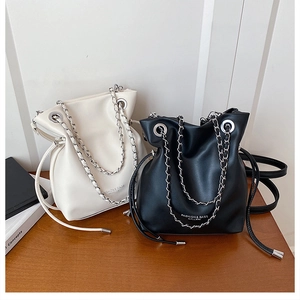 Detail of minimalist bucket bags with silver chain straps and drawstring metal eyelets