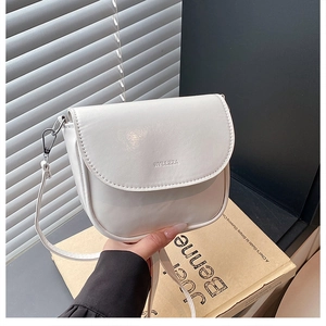 Dettaglio della borsa a sella bianca in ecopelle con logo del marchio e fibbia argentata