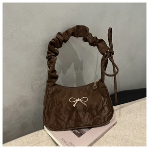 Détail du sac croissant plissé marron foncé avec boucle nœud doré et anse nuageuse