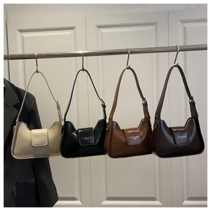 Various colors of leather baguette bags hanging on a rack showing minimalist style