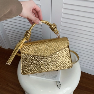 Golden python texture crossbody bag with knotted handle shown in lifestyle setting