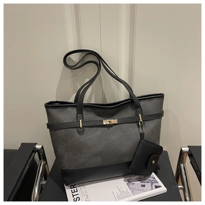 Macro shot of large tote bag featuring dark grey textured fabric and golden clasp lock