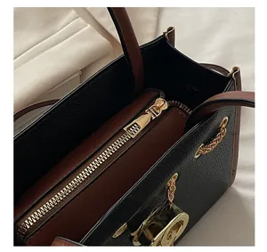 Detail view of large tote bag with zipper compartment and gold chain link decoration
