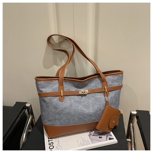 Detail of grey felt tote bag with brown leather trim and golden twist lock closure