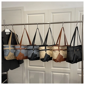 Detail view of large canvas tote bags with leather trim in six diverse color variations