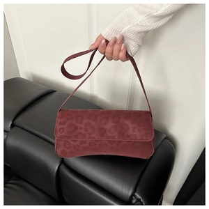 Detail of vintage burgundy leopard print shoulder bag with sleek curved base design