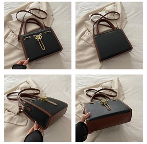 Detail showing contrast color design with gold chain decor and ring clasp on leather bag