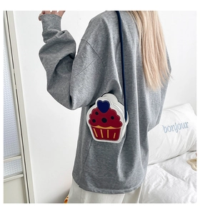 Detail shot of cute cupcake shaped crossbody bag with colorful patterns on a model