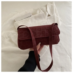 Detail of burgundy leopard texture suede shoulder bag with flap closure and slim strap