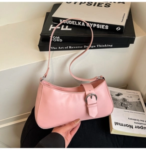 Detail of light pink crescent bag with silver buckle on elegant fashion design books