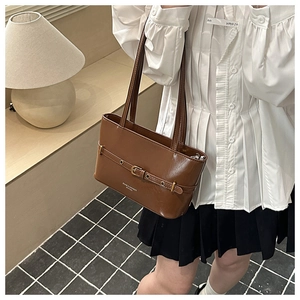 Détail du sac bandoulière rétro en cuir ciré marron avec boucle en métal et texte