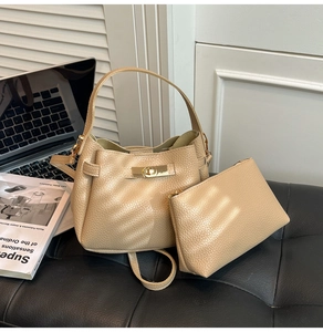 Detail of champagne lychee grain leather handbag set with gold turn-lock and accessories