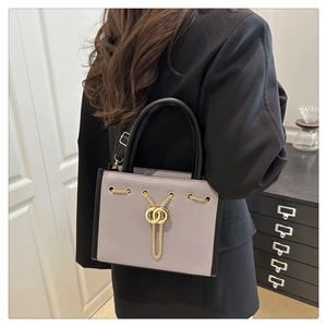 Detail of lavender tote bag with gold chain accent and contrast black side panels