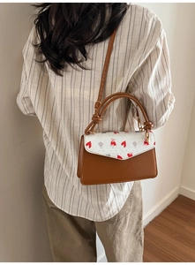 Detail of vintage crossbody bag showing cherry print and bear pattern on the side view