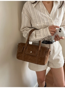 Détail du sac cabas en daim marron avec surpiqûres blanches et boucle argentée