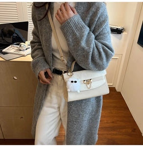 White minimalist crossbody square bag with gold lock and fluffy white faux fur pendant