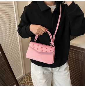 Détail du sac rose à imprimé fraises avec poignée nouée et bandoulière réglable