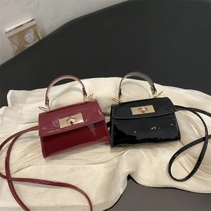 Glossy patent leather mini handbags in burgundy and black with sleek metal twist locks
