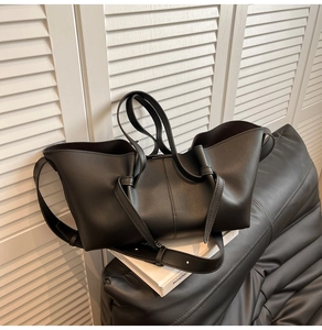 Detailed view of the knotted shoulder strap on this black matte leather oversized tote