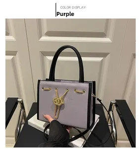 Detail view of purple tote bag with golden chain and double ring metal buckle