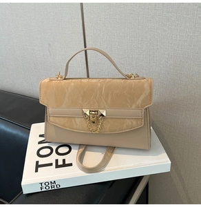 Close-up of beige crossbody bag with marble pattern flap and gold metal hardware lock