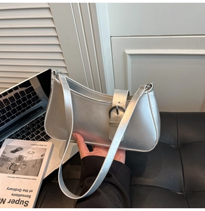 Details der silbernen Metallic-Baguette-Tasche mit Schnalle auf einem Schreibtisch