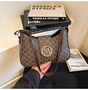 Detail of vintage monogram shoulder bag with gold M buckle on dark brown leather