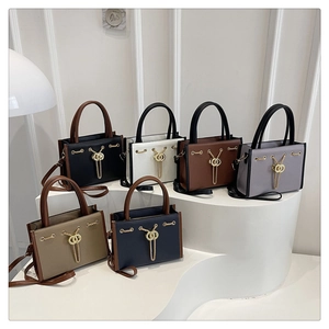 Six colors of large-capacity tote bags with chain decor on a white display stand
