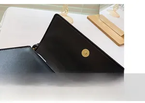 Detail of strong gold magnetic snap closure on premium black leather underarm bag