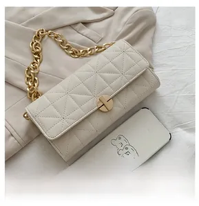 Dettaglio della borsa a tracolla trapuntata bianco off-white con catena dorata e fibbia