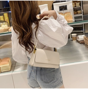Chic cream leather rectangular flap bag with slim shoulder strap and gold hardware