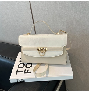 Detail of off-white crossbody bag with marble-textured flap and gold metal hardware finish