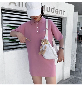 Outdoor shot of a white canvas crossbody bag featuring a cute 3D plush bear ornament