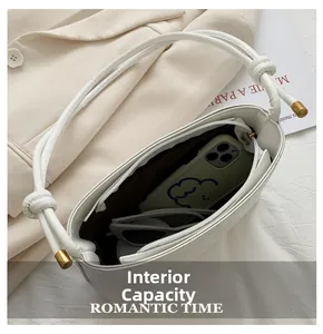 Détail du sac matelassé blanc montrant la capacité pour un smartphone et des lunettes