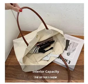 Interior view of the off-white canvas tote bag showing main compartment and inner pocket