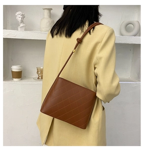 Dettaglio borsa a secchiello marrone trapuntata in pelle PU con tracolla a nodo decorativo
