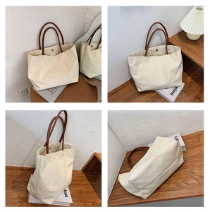 Detail view of cream canvas tote bag with brown leather handles and magnetic closure