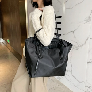 Large black nylon tote bag for women showing a minimalist shoulder style for daily commute