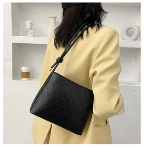 Détail du sac à bandoulière matelassé noir en cuir brillant avec bandoulière nouée