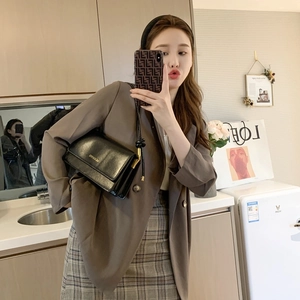 Minimalist black leather crossbody bag for women with gold logo and adjustable shoulder strap