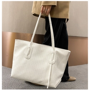 Close-up of white woven tote bag showing detailed checkerboard texture and slim handle