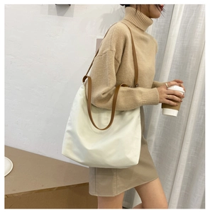 Minimalist beige tote bag with brown straps styled for a modern commute and daily use