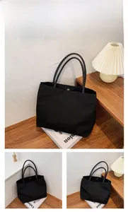 Detail of black canvas tote bag showing magnetic closure and slim shoulder straps