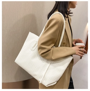 Detailed view of white woven texture on a large faux leather tote bag for women
